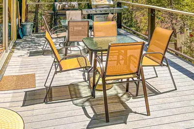 a group of chairs and a table on a deck at Alford Family Lodge in Bass Lake