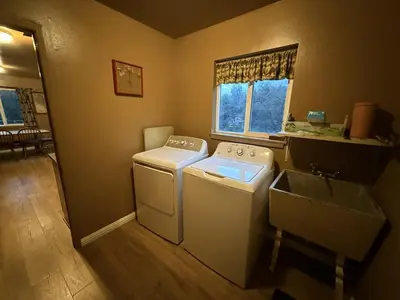 a laundry room with a washer and a sink at Hodges Hill Yosemite House in Oakhurst