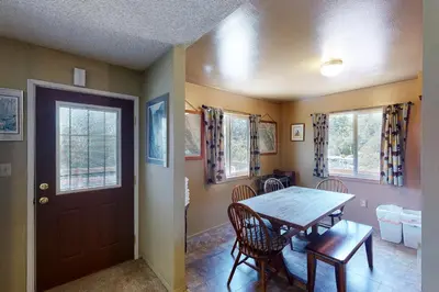 a dining room with a table and chairs and a door at Hodges Hill Yosemite House in Oakhurst