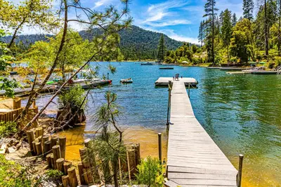 a dock on a lake with boats in the water at Todds Lakefront House in Bass Lake