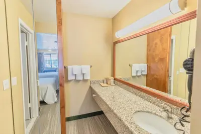a bathroom with a sink and a mirror at The Oakhurst Inn at Yosemite in Oakhurst