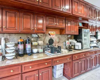 a kitchen with wooden cabinets and a counter top at The Oakhurst Inn at Yosemite in Oakhurst