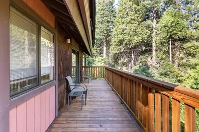 a porch of a cabin with chairs on it at Yosemite Big Rock Cabin in Fish Camp