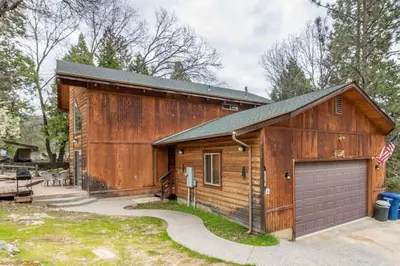 a large wooden building with a garage at Streiff Lake House in Bass Lake