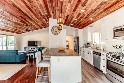 a kitchen with white cabinets and a wooden ceiling at Pine Ridge Peak in Oakhurst