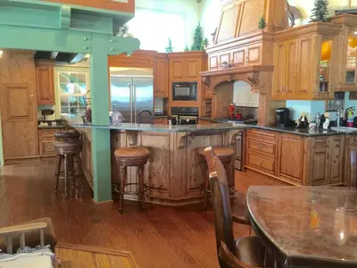 a large kitchen with wooden cabinets and a table at Knott Lakeview in Bass Lake
