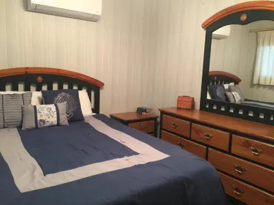 a bedroom with a bed and a dresser and a mirror at Knott Lakeview in Bass Lake