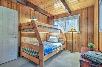 a bedroom with two bunk beds in a log cabin at Game Room and Deck Oso Cozy Cabin in Arnold! in Arnold
