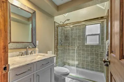 a bathroom with a sink and a toilet and a shower at Game Room and Deck Oso Cozy Cabin in Arnold! in Arnold