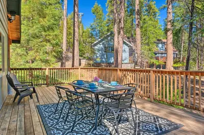 a table and chairs on a wooden deck at Game Room and Deck Oso Cozy Cabin in Arnold! in Arnold