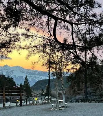 a sunset with benches and mountains in the background at Willow Springs Resort in Bridgeport