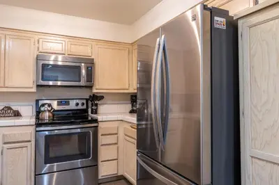 a kitchen with a stainless steel refrigerator and microwave at Warm and cozy upgraded 2 bedrm 2 bath single level condo in Snowcreek complex phase IV 563 Sleeps 6 in Mammoth Lakes