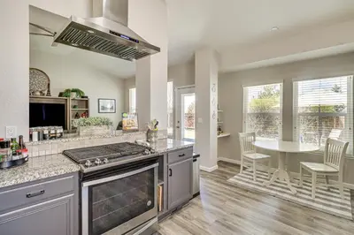 a kitchen with a stove top oven next to a table at 8 Mi to Dtwn Reno Cozy Sparks Escape with Fireplace in Sparks