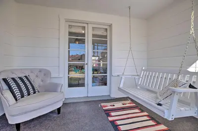 a porch with a swing and a chair and a window at Vintage Bishop House in Downtown with Porch Swing! in Bishop
