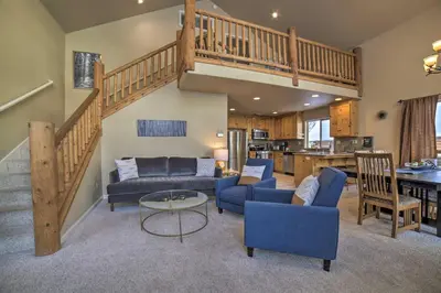 a living room with a couch and a staircase at Great for Groups Soda Springs Cabin with Deck! in Soda Springs