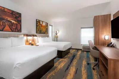 a hotel room with two beds and a desk at La Quinta Inn & Suites by Wyndham Galt Lodi North in Galt