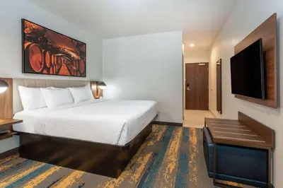 a hotel room with a bed and a flat screen tv at La Quinta Inn & Suites by Wyndham Galt Lodi North in Galt