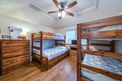 a bedroom with two bunk beds and a ceiling fan at Black Bear Cabin in Bass Lake