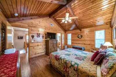 a bedroom with a bed and a wooden ceiling at Black Bear Cabin in Bass Lake