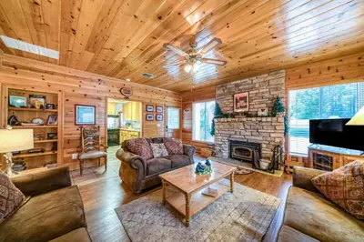 a living room filled with furniture and a fireplace at Black Bear Cabin in Bass Lake