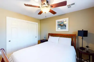 a bedroom with a white bed with a ceiling fan at Northshore Lakeview Getaway in Bass Lake