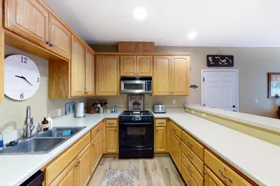 a kitchen with wooden cabinets and a black stove top oven at Northshore Lakeview Getaway in Bass Lake