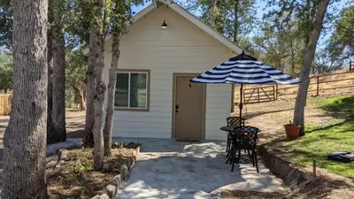 a house with a table and an umbrella at Clingan's Junction Cottage #4 in Squaw Valley