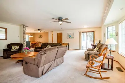 a living room with furniture and a ceiling fan at Deck and Hot Tub Rustic Groveland Home! in Groveland