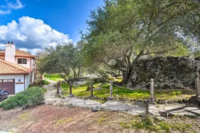a house with a tree and a fence at Romantic Treetop Studio 30 Mi to Yosemite! in Coarsegold