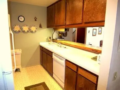 a kitchen with wooden cabinets and a white sink at 2 Bedrooms Premium Condos in Mammoth Lakes