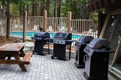 a group of grill and picnic tables and a bench at 2 Bedrooms Premium Condos in Mammoth Lakes