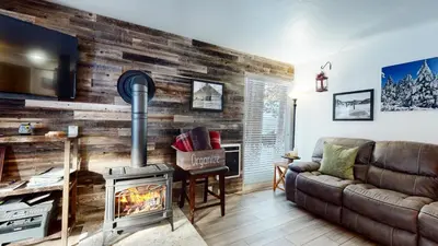 a living room with a fireplace and a couch at Mammoth Estates Condo - Free Parking & Pet Friendly in Mammoth Lakes