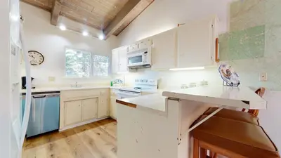 a kitchen with white cabinets and blue appliances at Mammoth Estates Condo - Near Village at Mammoth & Pet Friendly in Mammoth Lakes