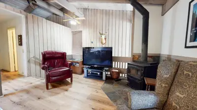 a living room with a couch and a television and a chair at Mammoth Estates Condo - Near Village at Mammoth & Pet Friendly in Mammoth Lakes