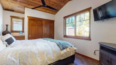 a bedroom with a bed and a flat screen tv at Grayfox 2 Pet-Friendly, 5-Star with Private Hot Tub, 2 Car Garage and Prime Location condo in Mammoth Lakes