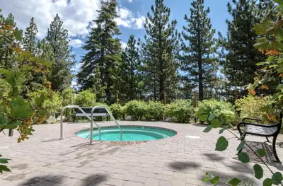 a small pool in a patio with a bench and trees at Solstice 11 Amazing Location on Golf Course, Heated Garage, Private Washer Dryer condo in Mammoth Lakes
