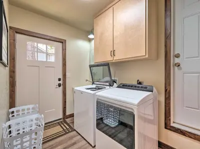 a washer and dryer in a room with a door at Woodsy Retreat Modern Mi-Wuk Village Cabin! in Mi-Wuk Village