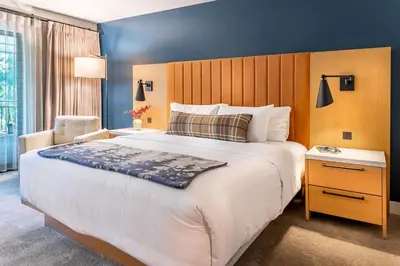 a hotel room with a large bed and a chair at The Incline Lodge in Incline Village