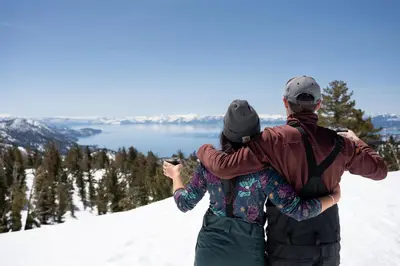a man and woman standing on top of a snow covered mountain at The Incline Lodge in Incline Village