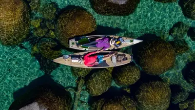 a woman is sitting on a surfboard in the water at The Incline Lodge in Incline Village