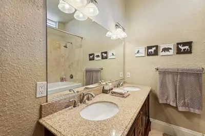 a bathroom with two sinks and a large mirror at Luxury Auberry Retreat in Sierra National Forest in Auberry