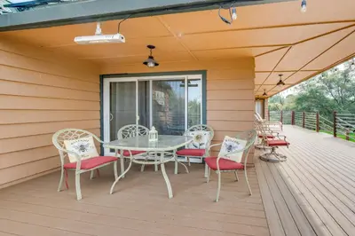 a patio with a table and chairs on a deck at Luxury Auberry Retreat in Sierra National Forest in Auberry
