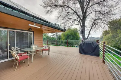 a wooden deck with a table and chairs on a house at Luxury Auberry Retreat in Sierra National Forest in Auberry