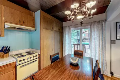 a kitchen with a wooden table and a dining room at Hidden Haven in Arnold