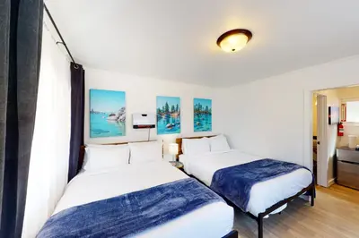 two beds in a room with white walls at The Chalet at Kings Beach Unit 1 in Kings Beach