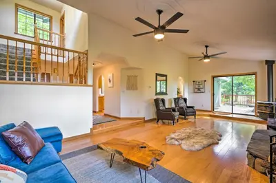 a living room with a blue couch and a table at 10 Acres with Stunning Views Apple Hill Home! in Camino
