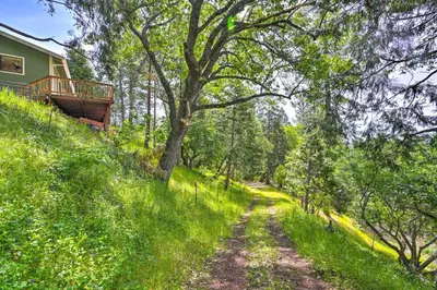 a dirt road leading to a house in the woods at 10 Acres with Stunning Views Apple Hill Home! in Camino