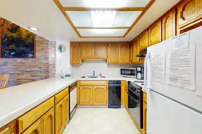 a kitchen with wooden cabinets and a white refrigerator at Lake Village Townhouse B in Zephyr Cove
