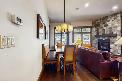 a living room with a table and a fireplace at Northstar Lodge Luxury in Kingswood Estates