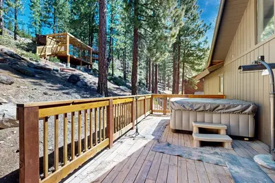 a deck with a hot tub and a bench on a house at Tyner Dreams in Incline Village